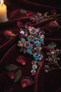 Broche florale strass violet et bleu sur velours bordeaux